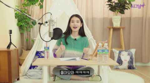 IU公开Youtube新项目《IU的宅家Signal》预告，说着「点赞」时直接笑场了